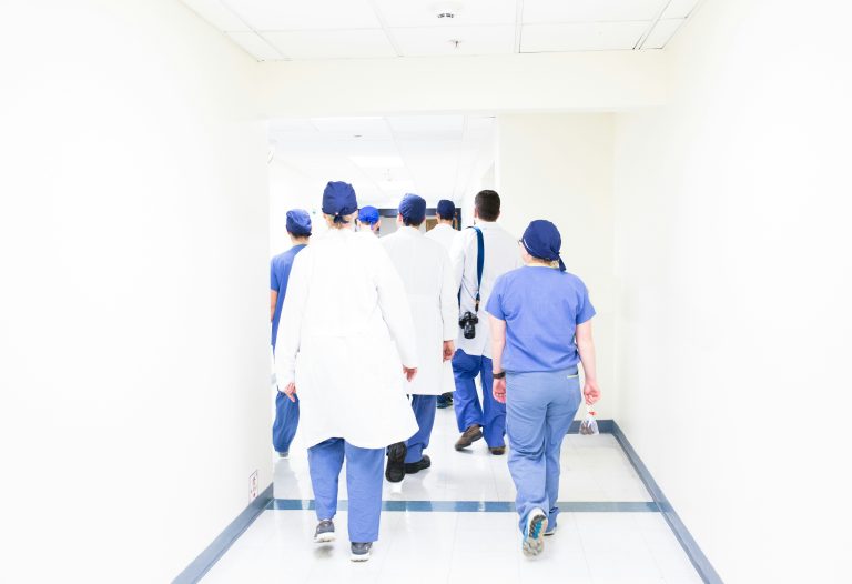 Team ospedaliero di medici e infermieri che camminano lungo il corridoio dell'ospedale