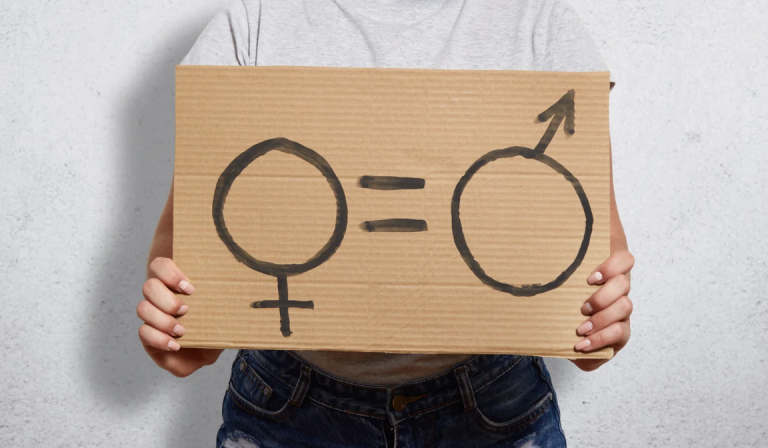 Donna che tiene in mano un cartellone sulla parità di genere