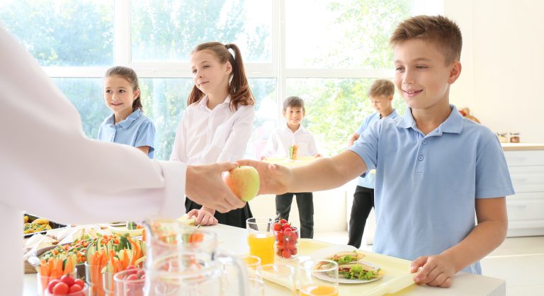 Bambini che prendono del cibo in una mensa scolastica